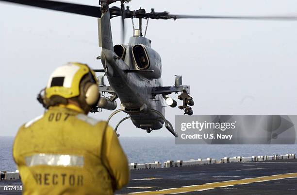 Flight deck director, Aviation Boatswains Mate 3rd Class Thomas Sanchez from Fontana, CA, watches an AH-1W "Super Cobra" helicopter from the...