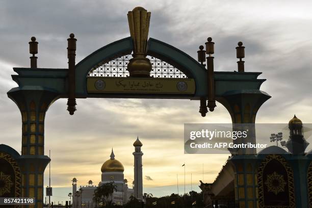 An archway with traditional Jawi and Latin script in Bahasa Melayu reads "A fair king brings happiness" is seen in front of Brunei's Sultan Omar Ali...