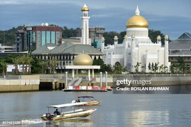 Boats are seen past Brunei's Sultan Omar Ali Saifuddin mosque in Bandar Seri Begawan on October 4, 2017. - Brunei will mark its Sultan's Hassanal...