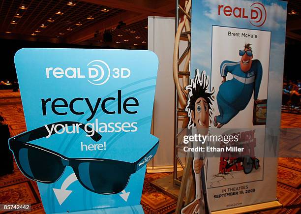 Recycle bin for RealD 3D glasses stands next to a poster for the 3D movie "Cloudy with a Chance of Meatballs" during ShoWest, the official convention...