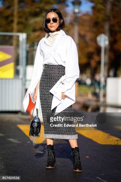 Yoyo Cao wears a white flare sleeves shirt, a checkered skirt, black shoes, a chanel bag, outside Chanel, during Paris Fashion Week Womenswear...