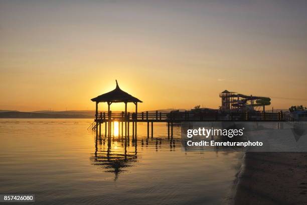 silhouette of a pier at dawn in cesme . - izmir sunrise stock pictures, royalty-free photos & images