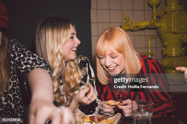 girlfriends on a night out - blond women happy eating stock pictures, royalty-free photos & images