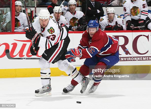 Aaron Johnson of the Chicago Blackhawks passes the puck as Saku Koivu of the Montreal Canadiens pressures on the forecheck at the Bell Centre March...