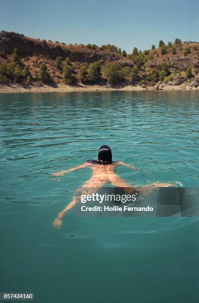 girl swimming in lake - women skinny dipping stockfoto's en -beelden