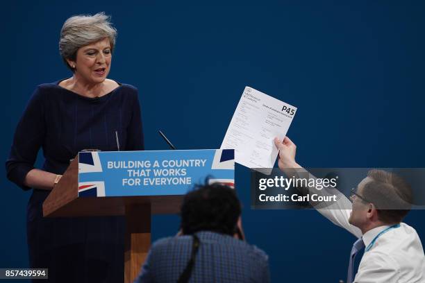 Comedian Simon Brodkin, aka prankster Lee Nelson, hands Prime Minister Theresa May a P45 during her keynote speech to delegates and party members on...