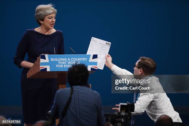 Comedian Simon Brodkin, aka prankster Lee Nelson, hands Prime Minister Theresa May a P45 during her keynote speech to delegates and party members on...
