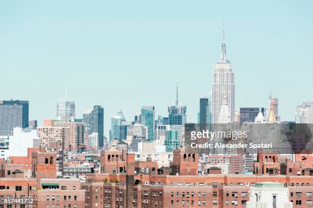 new york city skyline with empire state building on the right, ny, usa - pastellfarbig stock-fotos und bilder