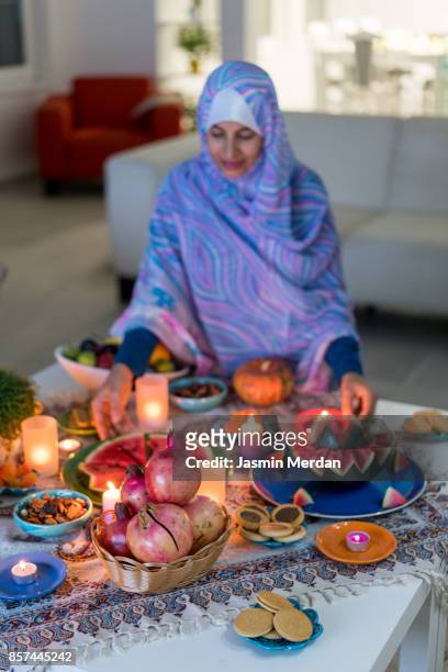 middle eastern woman preparing decorated table with food - cultura iraniana oriente médio - fotografias e filmes do acervo