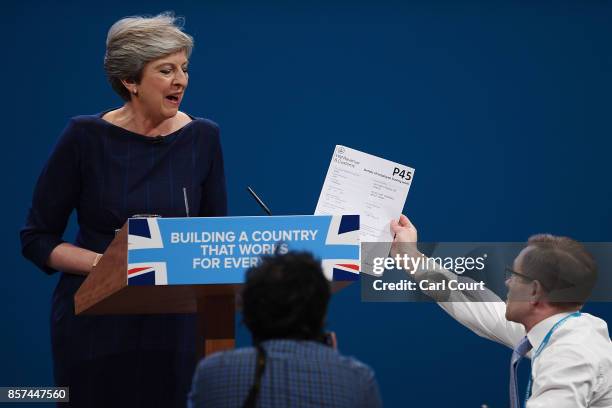 Comedian Simon Brodkin, aka prankster Lee Nelson, hands Prime Minister Theresa May a P45 during her keynote speech to delegates and party members on...