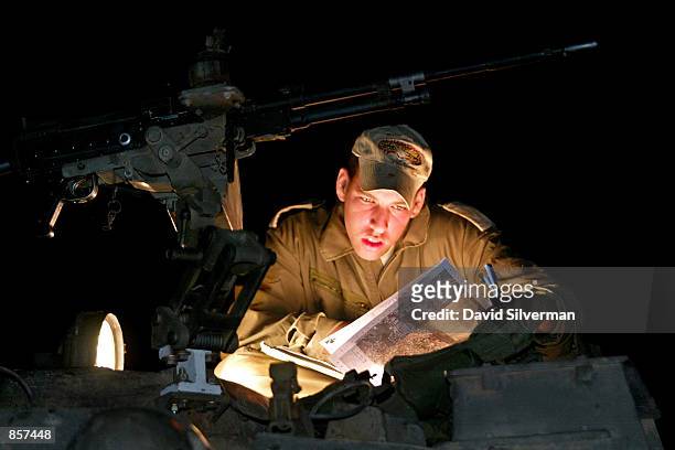 At a base at the Jewish settlement of Avnei Hefetz, an Israeli officer pores over his maps by the headlights of his tank ahead of military action...