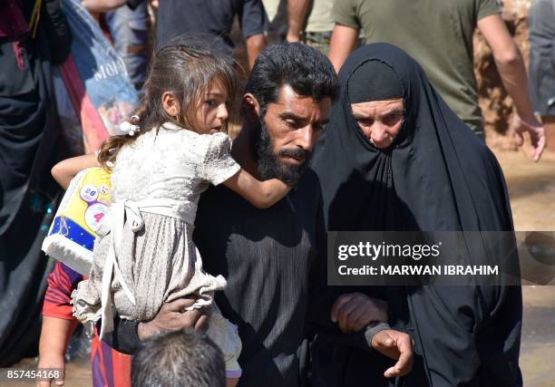 Displaced Iraqis who fled from the ongoing battles to oust the Islamic State group from Hawija, cross a river in the area of Zarga some 35 kilometres...