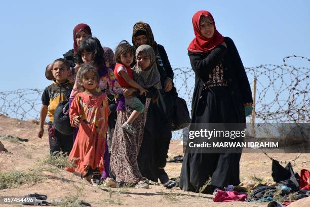 Displaced Iraqis who fled from the ongoing battles to oust the Islamic State group from Hawija, walk along the bank of a river in the area of Zarga...