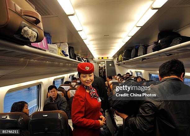 Stewardess directs passengers in a train car at Beijing West Railway Station on April 1, 2009 in Beijing, China. A new railway schedule, aimed at...