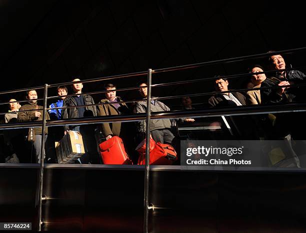 Passengers take an escalator to board a train at Beijing West Railway Station on April 1, 2009 in Beijing, China. A new railway schedule, aimed at...