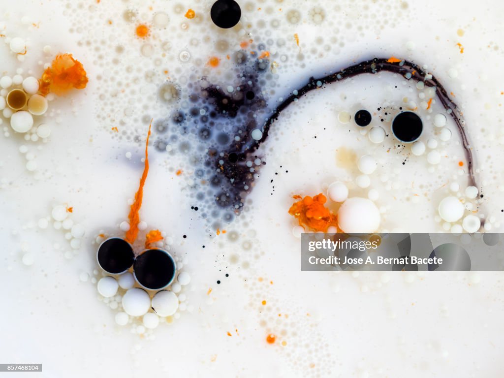 Full frame of abstract shapes and textures formed on a white and orange liquid background