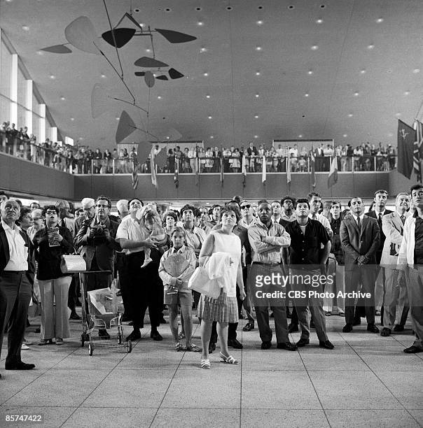 Interior view of the International Arrival Building at John F. Kennedy International Airport shows a crowd of passengers as they stand under a...