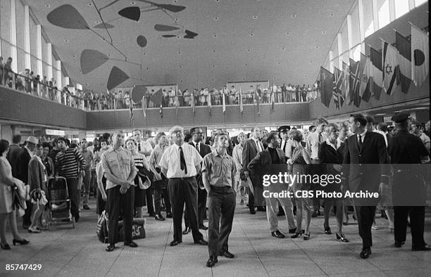 Interior view of the International Arrival Building at John F. Kennedy International Airport shows a crowd of passengers as they stand under a...
