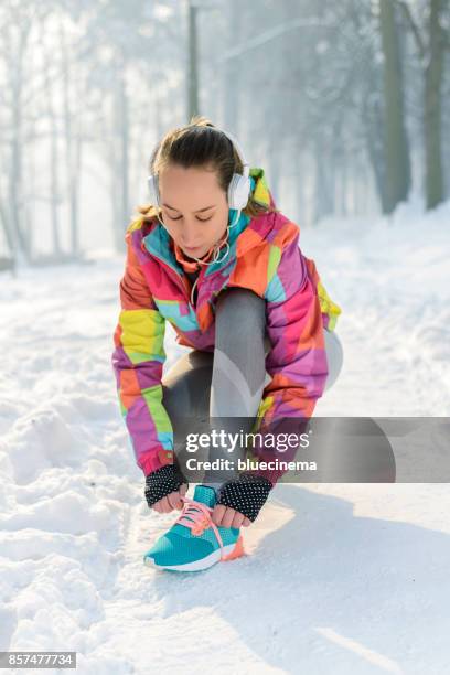young woman tying his shoelace - running spikes stock pictures, royalty-free photos & images