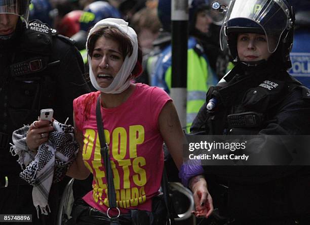 Climate change and anti-capitalist activist is led away after being injured during a demonstration outside a branch of the Royal Bank of Scotland on...