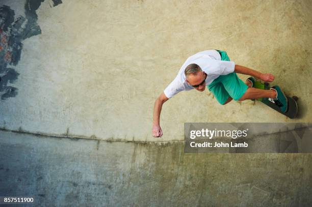 skateboarder high up on skatepark bowl - mens free skate imagens e fotografias de stock