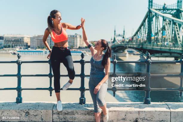 femmes sportives faisant cinq élevé après entraînement - after run photos et images de collection