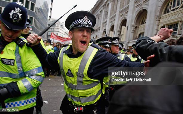 Police react to protesters as they block access to a branch of RBS stopping anti capitalist and climate change activists demonstrating in the City of...