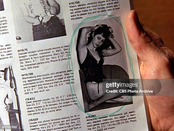 The hand of an unidentified actor holds a newspaper which features a photo of Ronette Pulaski from a sexually explicit personals column in a scene...