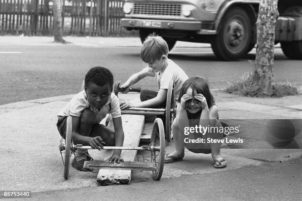 Three children build themselves a go-cart in the East End of London, 1960s.