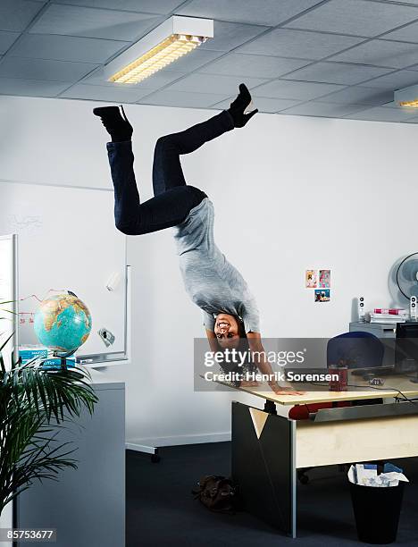 woman handstanding at the edge of her office table - upside down stock pictures, royalty-free photos & images