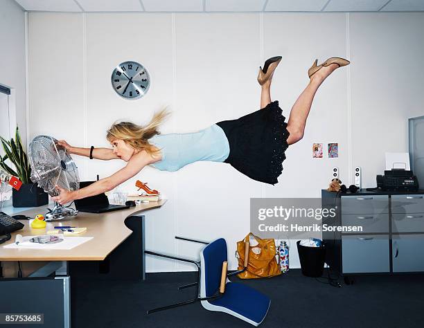 woman being blown away by a fan. - schlechte luft stock-fotos und bilder