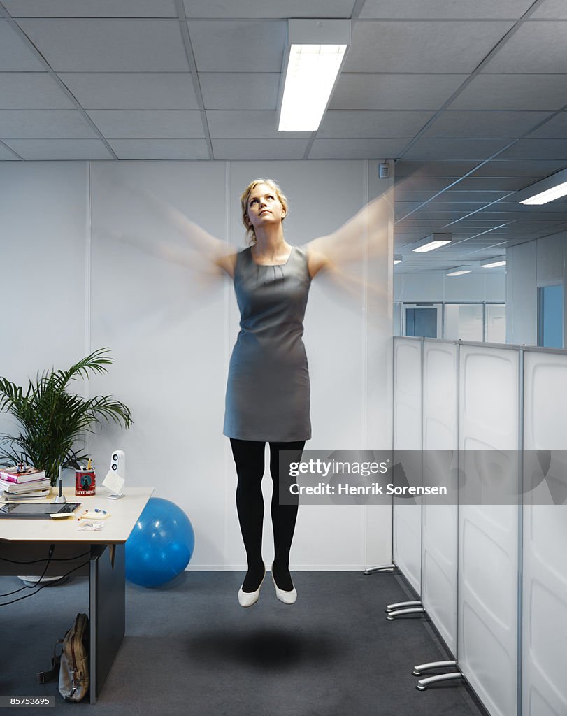 Woman flying in her office.