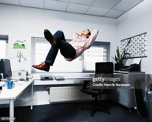 man floating in his office. - crazy job stock pictures, royalty-free photos & images