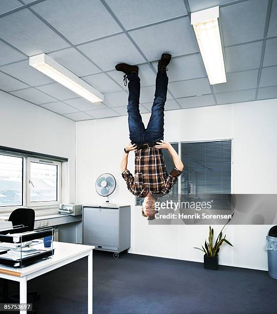 man standing upside down on the ceiling. - ceiling stock-fotos und bilder