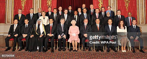 Queen Elizabeth II poses with delegates of the G20 London summit for a group photograph in the Throne Room at Buckingham Palace on April 1, 2009 in...
