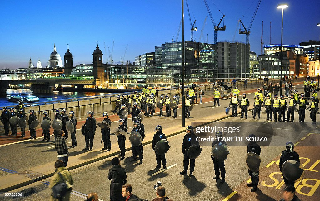 Riot police officers stand guard on Lond