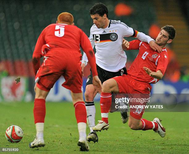 Germany's midfielder Michael Ballack vies with Wales' striker Ched Evans and Wales' midfielder James Collins during the FIFA World Cup 2010 European...