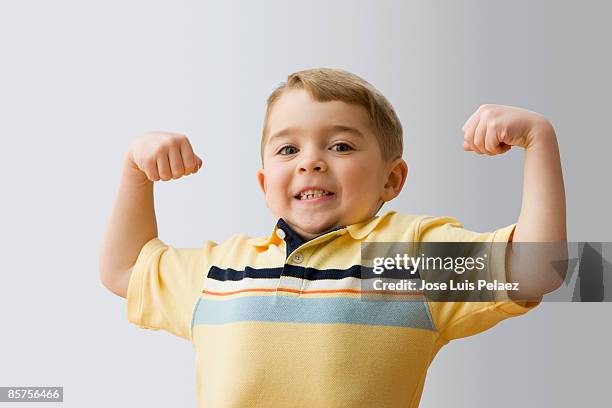 little boy making muscles - child strong stock-fotos und bilder