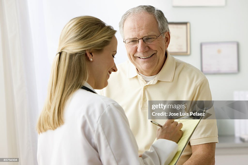 Female doctor taking notes on male patient