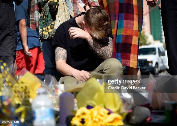 Bry Thompson of Las Vegas wipes his eyes at a makeshift memorial set up across from the Las Vegas Village on October 4, 2017 in Las Vegas, Nevada....