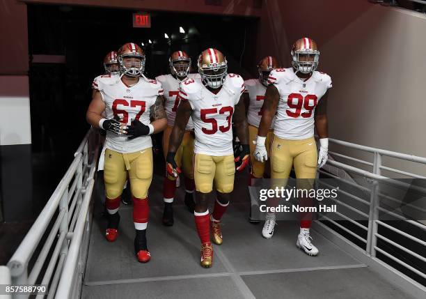 Daniel Kilgore, NaVorro Bowman and DeForest Buckner of the San Francisco 49ers walk to the field with their team behind them prior to a game against...