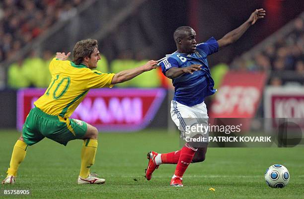 Lithuania's midfielder Mindaugas Kalonas vies with France's midfielder Lassana Diarra during the World Cup 2010 qualifying football match France vs...