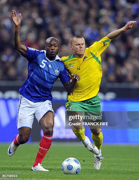 Lithuania's midfielder Darvydas Sernas vies with France's defender William Gallas during the World Cup 2010 qualifying football match France vs...