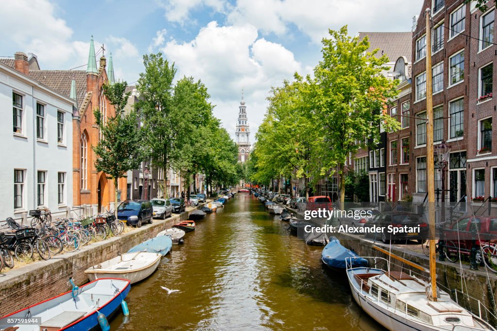 Church and boats moored along the canal in Amsterdam, Holland