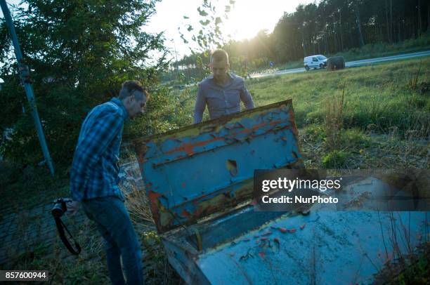 Two men are seen near a disused underground petrol tank on 30 September, 2017.