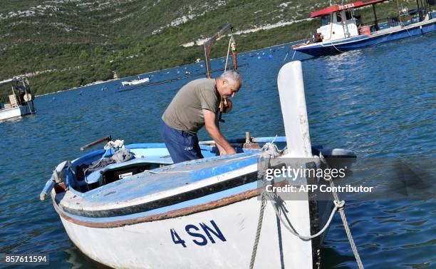 Picture taken on September 25 shows a shellfish farmer, Pero Brbora, in his boat near the town of Ston on the Peljesac Peninsula, southern Croatia....
