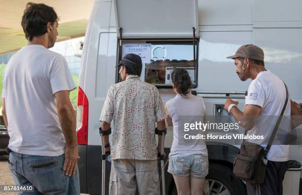 Patients wait outside a van parked near Praca Espanha to receive from male nurse Joao Matos their daily doses of 85 milligrams of methadone on...