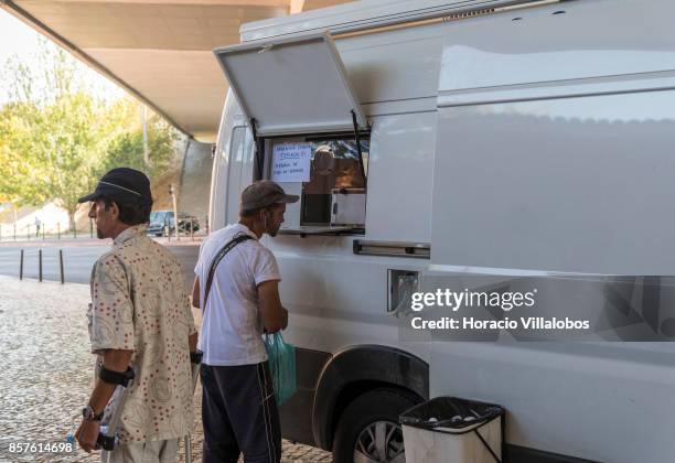 Patients wait to receive their daily doses of 85 milligrams of methadone outside a van parked near Praca Espanha on October 04, 2017 in Lisbon,...