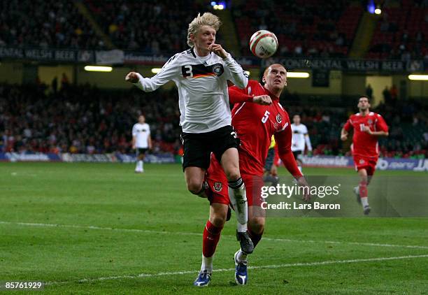 Andreas Beck of Germany is challenged by James Collins of Wales during the FIFA 2010 World Cup Group 4 Qualifier match between Wales and Germany at...