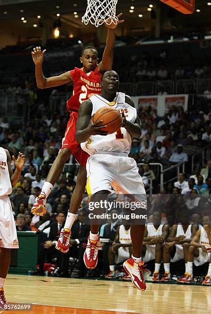 Lance Stephenson of the East Team drives under John Henson of the West Team in the 2009 McDonald's All American Men's High School Basketball Game at...